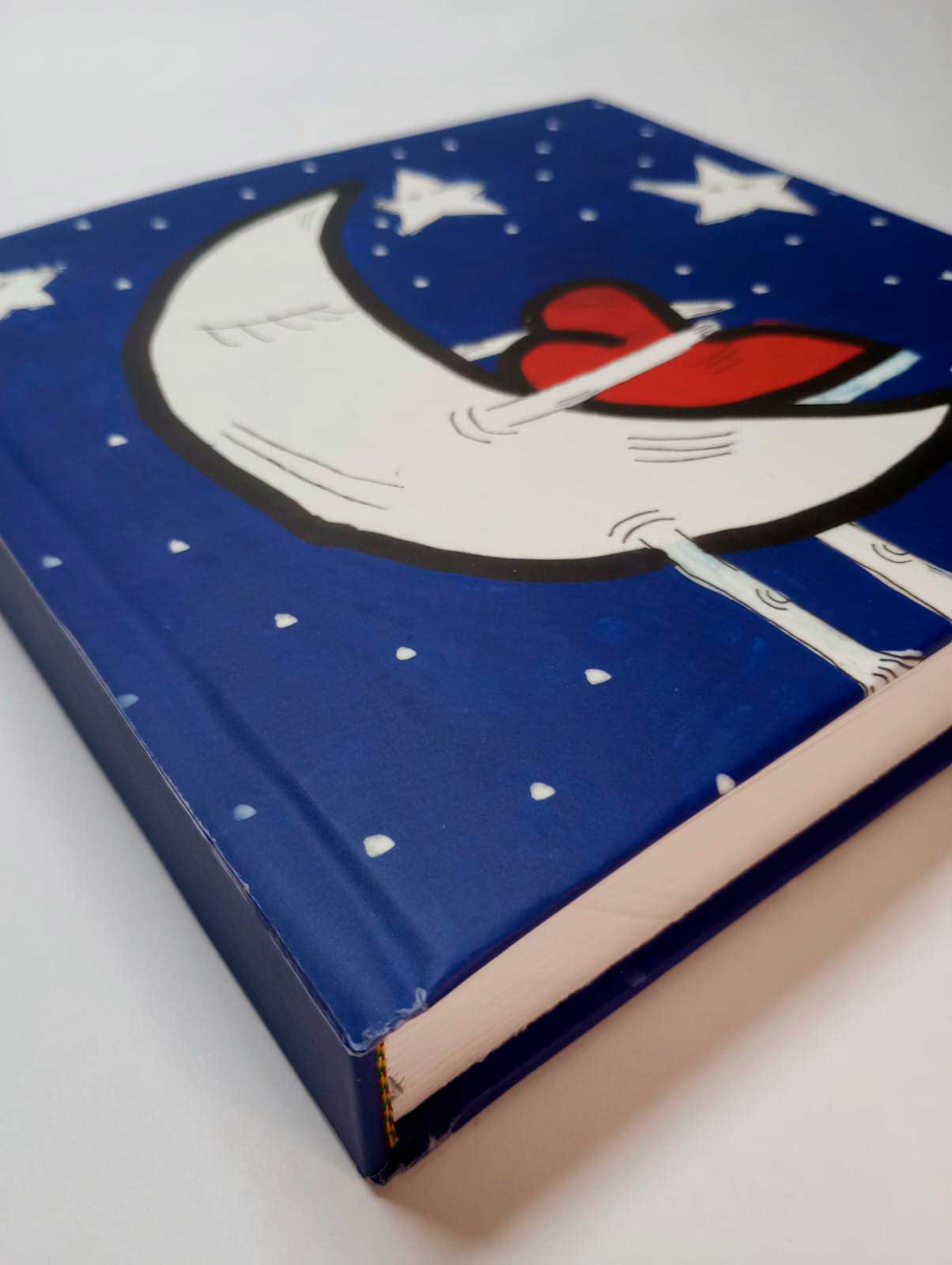 Detalle de la tapa del libro Noches de Julio Resek con ilustración de luna abrazando un corazón rojo