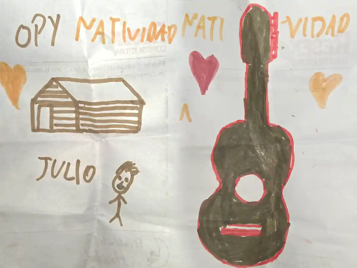 Dibujo realizado por Natividad, niña de la comunidad Mbya Guaraní Ivytu Porá, con un Opy, casa ceremonial Mbya, una guitarra, corazones y el nombre Julio, regalo para el ingeniero Julio Resek durante la visita a Constructora Resek, Posadas, Misiones, mayo 2026