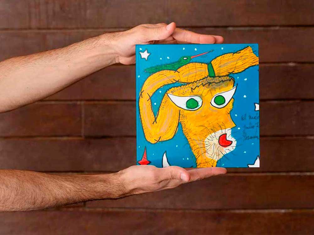 Ilustración original de un poema del libro Tus cielos de Julio Resek sostenida entre las manos